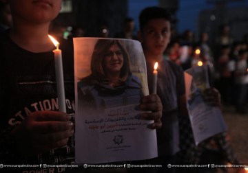 Awak media yang bertugas di Jalur Gaza menyalakan lilin untuk almarhumah jurnalis Palestina, Shireen Abu Akleh, selama aksi protes yang mengutuk pembunuhan Shireen oleh pasukan pendudukan Israel. Aksi ini dilakukan di puing-puing kantor Al-Jazeera yang di